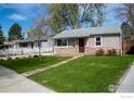 A quaint home with fresh green lawn and sidewalk leading to the front door at 128 E 5Th Ave, Longmont, CO 80504