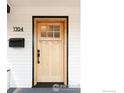 Close up of the home's natural wood front door featuring a black mailbox and house number at 1304 9Th Ave, Longmont, CO 80501