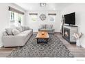 Bright living room featuring modern furnishings, a fireplace, and large windows at 1304 9Th Ave, Longmont, CO 80501