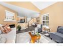 Cozy living room with hardwood floors, fireplace, and open floor plan leading to the dining area at 14246 Pikeminnow Pl, Broomfield, CO 80023