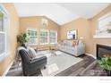 Bright living room with vaulted ceilings, fireplace, and large windows providing natural light at 14246 Pikeminnow Pl, Broomfield, CO 80023