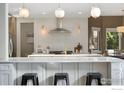 Bright kitchen boasts stainless appliances, large island with seating, and stylish decorative backsplash at 1702 Montgomery Cir, Longmont, CO 80504
