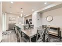 Open dining area with modern table, seating for six, and views of the kitchen at 17106 E Alameda Pkwy, Aurora, CO 80017