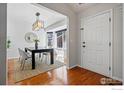 Inviting dining area with hardwood floors, a modern chandelier, and a sunny bay window at 1970 Hamron Ct, Erie, CO 80516