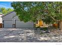A beautiful tree shades this residence, complemented by a well-manicured lawn and a two-car garage at 1970 Hamron Ct, Erie, CO 80516