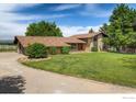 Lovely single-Gathering home with a long driveway, green lawn, and a well-maintained brick exterior at 2117 Stonehenge Cir, Lafayette, CO 80026