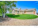 Well-maintained home with a large lawn, trimmed shrubs, and a decorative stone border, offering great curb appeal at 2212 S County Road 15 Rd, Berthoud, CO 80513
