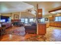 Inviting living room boasts a cozy fireplace, hardwood floors, and large windows providing plenty of natural light at 2212 S County Road 15 Rd, Berthoud, CO 80513