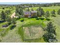 Aerial view of a two-story home, showing a fenced yard and well-manicured lawn at 2219 Meadow Green Cir, Franktown, CO 80116