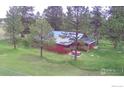 Aerial view of a home with mature trees and a well maintained lawn at 23891 Supai Rd, Indian Hills, CO 80454