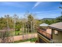View from the home's deck, complete with outdoor seating and scenic mountain views beyond at 25808 Sunrise Ln, Golden, CO 80401