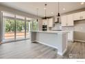 Open kitchen featuring a center island, stainless appliances, and sliding glass doors at 2710 Crystal Springs Ln, Longmont, CO 80503