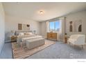 Bright main bedroom suite featuring a large window, neutral color palette, and stylish furniture at 2710 Crystal Springs Ln, Longmont, CO 80503