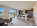 Modern kitchen featuring an island with seating, stainless steel appliances, and sliding glass doors to the deck at 2710 Crystal Springs, Longmont, CO 80503