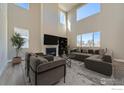 Bright living room with high ceilings, modern furniture, fireplace, and large windows at 2710 Crystal Springs, Longmont, CO 80503