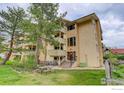 Apartment building with balconies, surrounded by mature trees and a picnic table on the grassy lawn at 3030 Oneal Pkwy # 10, Boulder, CO 80301