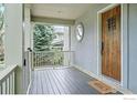 Cozy front porch with wood flooring, and a view of the yard and surrounding trees at 3219 7Th St, Boulder, CO 80304