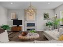 Modern living room with a stone fireplace, stylish light fixture, and hardwood floors at 3663 Silverton St, Boulder, CO 80301