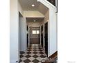 Hallway boasts striking checkered tile floors, white walls, and black paneled doors leading to various rooms at 410 Superior Dr, Superior, CO 80027