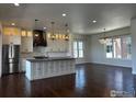 Open-concept kitchen showcases an island, stainless steel appliances, and dark hardwood flooring at 410 Superior Dr, Superior, CO 80027