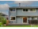 Exterior view of the back of the home with a wooden deck, a sliding door and a glimpse of the backyard at 4140 Monroe Dr # C, Boulder, CO 80303