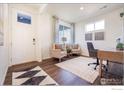 Bright home office featuring modern decor, hardwood floors, a large window and comfortable seating at 4204 Sandstone Dr, Mead, CO 80504