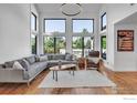 Bright living room with soaring ceilings, large windows, and modern furnishings at 426 W Spruce Ln, Louisville, CO 80027