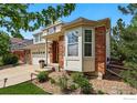 Beautiful home exterior showcasing brick accents, a bay window, and landscaped garden beds at 4915 Sage Brush Dr, Broomfield, CO 80023