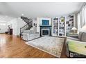 Spacious living room with hardwood floors, a fireplace, built-in bookshelves, and neutral tones at 4915 Sage Brush Dr, Broomfield, CO 80023