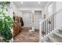 Bright entryway with hardwood floors, stylish rug, staircase, and decorative accents at 4940 Preserve Pl, Firestone, CO 80504