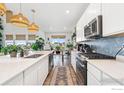 Modern kitchen featuring a large island, stainless steel appliances, and stylish backsplash at 4940 Preserve Pl, Firestone, CO 80504