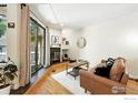 Bright living room featuring a cozy fireplace, wood floors, and a sliding door to the outdoor deck at 5016 Buckingham Rd # 4, Boulder, CO 80301