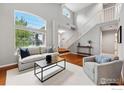 Bright living room with hardwood floors, large windows, and a neutral color palette, creating an inviting space at 6105 El Diente Cir, Golden, CO 80403