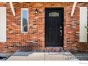 Elegant front door featuring a decorative glass insert and detailed brick surround at 719 Marshall Pl, Berthoud, CO 80513