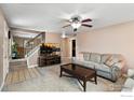 Inviting living room featuring a staircase, comfortable seating, and modern entertainment center at 719 Marshall Pl, Berthoud, CO 80513
