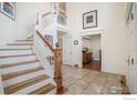 Bright foyer featuring an open staircase, tile flooring, and high ceilings at 7528 Estate Cir, Niwot, CO 80503