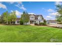 Beautiful grey home with a lush green lawn and detached garage at 10481 Oxford Rd, Longmont, CO 80504
