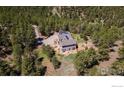 Aerial view of a beautiful home surrounded by lush green trees on a sprawling lot in a serene setting at 1057 Reed Ranch Rd, Boulder, CO 80302