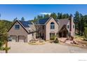 Attractive two-story home equipped with solar panels, a two car garage and a decorative gabled front entry at 1057 Reed Ranch Rd, Boulder, CO 80302