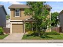 Charming two-story home featuring a well-manicured lawn, attached garage, and inviting front porch at 10667 Durango Pl, Longmont, CO 80504