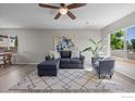 Comfortable living room with large window, ceiling fan, and stylish furniture arrangement at 10667 Durango Pl, Longmont, CO 80504