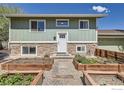 Inviting home exterior with stone accents, raised garden beds, and a well-maintained yard at 1085 Malory St, Lafayette, CO 80026