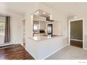 Bright living area featuring hardwood floors, modern lighting, and an open floor plan to the kitchen at 1085 Malory St, Lafayette, CO 80026