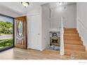 Bright entryway with hardwood floors, fireplace, and staircase leading to the upper level at 1250 Acropolis Dr, Lafayette, CO 80026