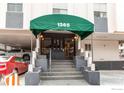 Building entrance at 1265 featuring a green awning and brick steps at 1265 Race St # 408, Denver, CO 80206