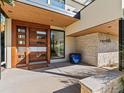 Modern front entry featuring a unique wood door, stone accent wall, and sleek design elements at 1445 Moss Rock Pl, Boulder, CO 80304