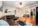 Spacious living room with hardwood floors, a ceiling fan, and a comfortable leather couch at 159 Virginia Canyon Rd, Idaho Springs, CO 80452