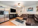 Inviting living room with stainless steel refrigerator, a ceiling fan, and a comfortable leather couch at 159 Virginia Canyon Rd, Idaho Springs, CO 80452