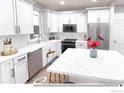 Bright kitchen featuring white cabinets, stainless steel appliances, and a center island with marble countertop at 1606 W 166Th Ave, Broomfield, CO 80023