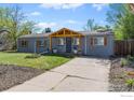 Charming home featuring a gray exterior, a welcoming wooden porch, and a long driveway at 1970 Willow St, Denver, CO 80220